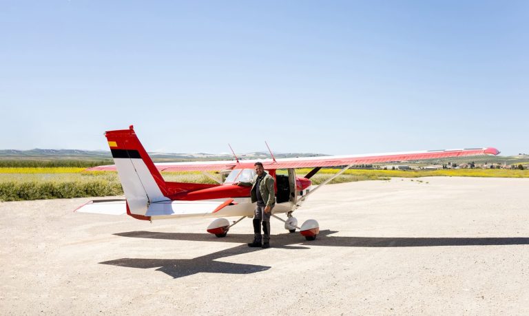 A man standing next to a light aircraft he is considering purchasing