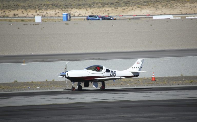 Small aircraft taxiing down the runway approach, side view on a sunny day