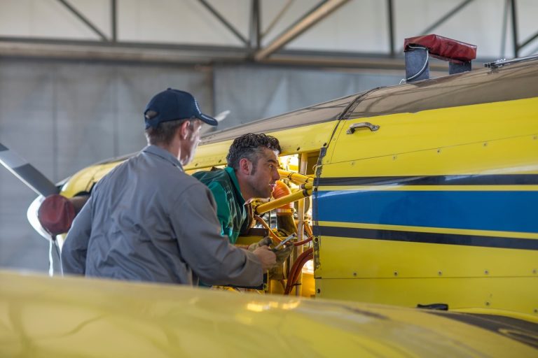 A man with an aircraft mechanic, doing a prepurchase inspection of a light aircraft